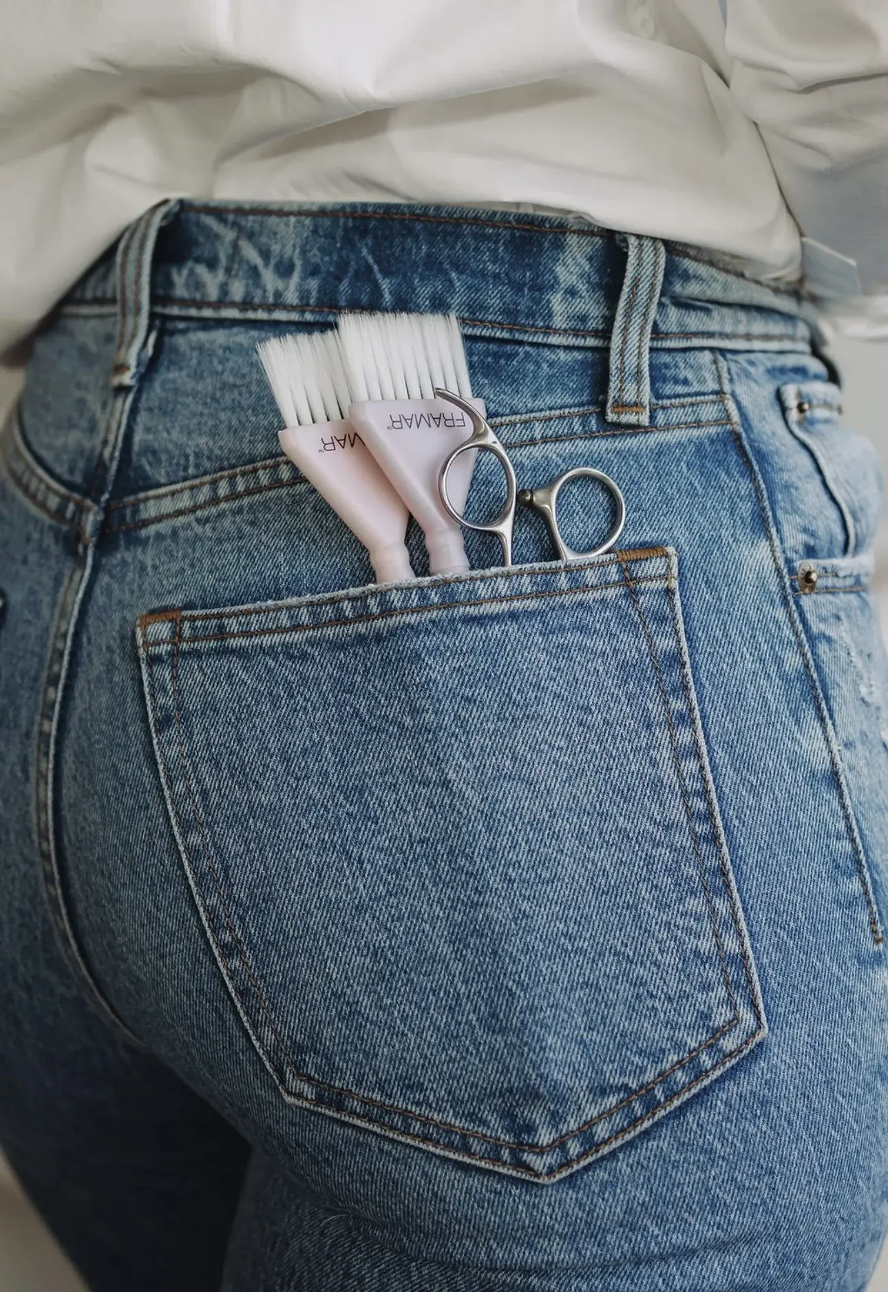 Color brushes and shears in a back pocket