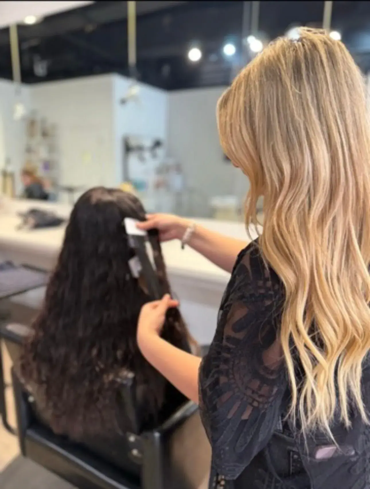 A stylist installing tape-in extensions